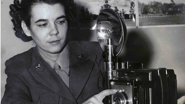 Portrait of Charlotte Mansfield with the Speed Graphic camera that she used during World War II. Courtesy of the Florida State University Institute on World War II and the Human Experience.